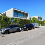 Eduardo Souto de Moura’s Utopia Villa 7 showcasing a modern automotive exterior with sleek car doors, luxury vehicles, and reflective rear-view mirrors integrated into the design.