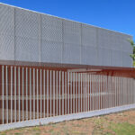 Gonçalo Byrne’s Utopia Villa 3 showcasing a modern home fencing design with composite material walls, metal mesh panels, and engineered shade structures.