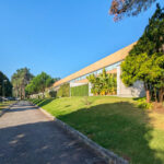 "Quinta da Barca Row House 1 "" Casa do Pinhal"" ", Esposende by João Alvaro Rocha (3725) João Alvaro Rocha’s Casa do Pinhal showcasing a modern structure with large glass façades, surrounded by landscaped garden with trees, plants, a lawn, and a paved walkway.