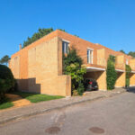 Quinta da Barca Row House 2, Esposende by João Alvaro Rocha (3730) João Alvaro Rocha’s Quinta da Barca Row House 1 showcasing a brick hacienda-style villa with a driveway lined by palm trees and a neatly trimmed hedge.
