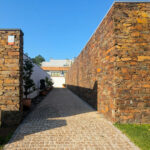 Quinta da Barca Villa 1, Esposende by João Alvaro Rocha (3721) João Alvaro Rocha’s Quinta da Barca Villa 1 showcasing a stone and brick composite wall with detailed brickwork and a cobblestone walkway.
