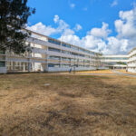 Vítor Figueiredo’s design of Escola Superior de Artes e Design showcasing a modern campus building with a glass façade, shaded outdoor areas, and a sleek, corporate headquarters style.