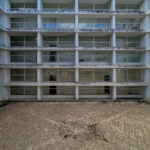 Vítor Figueiredo’s Escola Superior de Artes e Design showcasing a high-rise building with concrete and composite materials, featuring glass balconies and engineered daylighting elements.