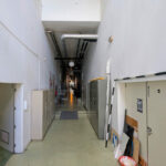 Vítor Figueiredo’s Escola Superior de Artes e Design showcasing a modern interior with composite material flooring, metal and steel structural elements, tiled floor, ceiling light fixtures, and visible electrical supply components.