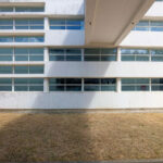 Vítor Figueiredo’s design of Escola Superior de Artes e Design showcasing a commercial building with composite material and concrete elements, featuring large windows for daylighting and shaded areas on the corporate headquarters façade.