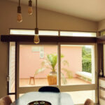 Casa Veiga / Casa Portufornia, Colares by Manuel Tainha, Rui Costa Martins (3740) Interior view of Casa Veiga by Manuel Tainha and Rui Costa Martins showcasing modern wood flooring, elegant ceiling with integrated lighting, contemporary furniture, and a distinctive chandelier light fixture.