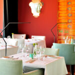 Nuno Graça Moura’s Tennis Club, Lot 161 interior showcasing modern restaurant design with textile-covered tables, elegant chairs, stemware, and refined linens creating a sophisticated dining atmosphere.