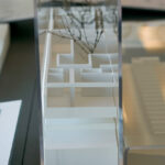 Inês Lobo’s 18 Architectural Townhouses, Lot 126, showcasing a modern design with silver aluminium composite materials, extensive glass façades, and transparent display cases.