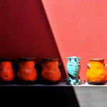 Nuno Graça Moura’s Tennis Club, Lot 161, showcasing a modern design with a distinctive orange pottery vase sculpture integrated into the stoneware and ceramic elements, highlighted by creative arts-inspired still life arrangements and subtle shadow play.