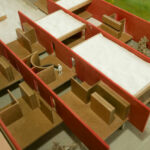 Gonçalo Byrne’s architectural project "6 Unbuilt Villas, Lot 209" showcasing a detailed scale model with floor plans and plywood assemblies highlighting the layout and structural design.