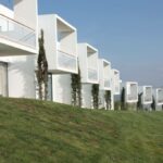 Gonçalo Cardoso de Menezes’ 21 Architectural Townhouses, Lot 154, showcasing a modern residential complex with landscaped gardens, balconies, hedges, and an urban design featuring multiple attached homes on a land lot.