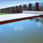 Gonçalo Byrne’s 25 Architectural Townhouses "Rusty Gates," Lot 217, showcasing composite material façades with reflective surfaces overlooking a water feature and swimming pool casting shadows.