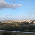 Alcino Soutinho’s 10 Architectural Villas, Lot 240, showcasing minimalist villas with clean lines, flat roofs, and large glass windows set against a plain hinterland under a clear daytime sky.