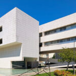 Alcino Soutinho’s Biblioteca Municipal Florbela Espanca showcasing a brutalist architecture style with exposed concrete surfaces, large daylighting windows, and a mixed-use urban design integrating commercial and condominium spaces.