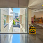 Alcino Soutinho’s Biblioteca Municipal Florbela Espanca showcasing a modern public library with extensive shelving, composite material bookcases, large glass windows for natural daylighting, and a sleek architectural design.