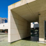 Alcino Soutinho’s Biblioteca Municipal Florbela Espanca showcasing a modern concrete structure with composite materials, featuring a clean, geometric design in an urban metropolitan setting during daytime.