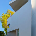 Alcino Soutinho’s Cavadas Santos Residence showcasing a modern composite material façade with a prominent balcony extending from the structure.