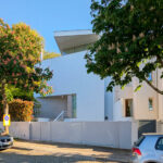 Alcino Soutinho’s Cavadas Santos Residence showcasing a modern residential design with composite material façade and multiple balconies overlooking an urban area.