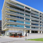 Alcino Soutinho’s Conjunto Habitacional Palácio da Enseada showcasing a high-rise mixed-use condominium with a modern glass façade and urban design elements in a metropolitan area.