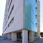 Alcino Soutinho’s Conjunto Habitacional Palácio da Enseada showcasing a high-rise condominium with concrete and composite materials, featuring a modern corporate headquarters design under daytime lighting.