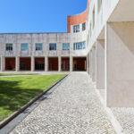 Alcino Soutinho's Department of Ceramics and Glass Engineering at the University of Aveiro showcasing a composite material facade with daylighting features, surrounded by a lawn and courtyard on the campus.
