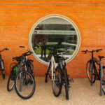 Alcino Soutinho's Department of Ceramics and Glass Engineering at the University of Aveiro with a modern design featuring bicycles parked in front, highlighting bicycle wheels, frames, and handlebars.