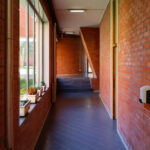 Alcino Soutinho's Department of Ceramics and Glass Engineering at the University of Aveiro showcasing an interior with brick walls, wooden flooring, and a stained wood ceiling.