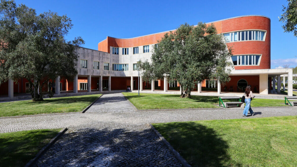 Alcino Soutinho's Faculty of Ceramics and Glass Engineering at the University of Aveiro showcasing a modern urban design with a prominent facade, landscaped lawn, and shaded areas.