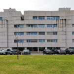 Alcino Soutinho’s Edifício Delfim Pereira da Costa showcasing a high-rise commercial building with a composite material façade, featuring modern urban design elements and a sleek, engineered structure under daytime lighting.