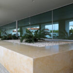 Alcino Soutinho’s Edifício Delfim Pereira da Costa interior showcasing natural concrete flooring and ceiling with tiled surfaces and ample daylighting.