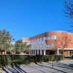 Alcino Soutinho's Faculty of Ceramics and Glass Engineering at the University of Aveiro showcasing a modern urban design with a prominent facade, landscaped lawn, and shaded areas.
