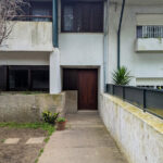 Alcino Soutinho’s Habitação unifamiliar em Matosinhos showcasing a modern residential building with concrete and composite materials, featuring balconies, external stairs, plaster and cement finishes, and designed to optimize daylighting and shade.