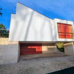 Alcino Soutinho's Habitação unifamiliar em Ofir showcasing a modern design with concrete and composite materials, featuring daylighting elements, painted surfaces, and visible stairs.