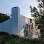 Alcino Soutinho's Habitação unifamiliar em Ofir showcasing a modern concrete structure with composite materials, highlighted by daylighting and shadows during the daytime.