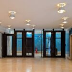 Alcino Soutinho's Matosinhos Town Hall showcasing a modern interior design with tile flooring, glass doors, and contemporary light fixtures.