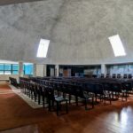 Alcino Soutinho's Matosinhos Town Hall showcasing a symmetrical design with a prominent dome, engineered ceiling, and daylighting features enhanced by modern light fixtures.