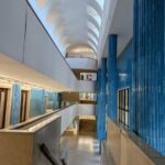 Alcino Soutinho's Matosinhos Town Hall showcasing a symmetrical design with a prominent glass façade, composite materials, and reflective tiles under a clear blue daytime sky.