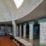 Alcino Soutinho's Matosinhos Town Hall showcasing a modern design with a concrete structure, expansive glass windows, and interior elements like tile flooring and daylighting features.