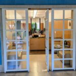 Alcino Soutinho's Matosinhos Town Hall showcasing a modern interior design with clean flooring, glass doors, and houseplants enhancing the space.