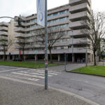 Alcino Soutinho’s Quinta das Sedas showcasing a modern commercial building with composite material façade, large glass panels, and integrated public urban space in a metropolitan area during daytime.