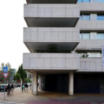 Alcino Soutinho’s Quinta das Sedas showcasing a high-rise commercial building with a brutalist concrete façade, composite materials, and urban design elements.