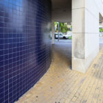 Alcino Soutinho’s Quinta das Sedas showcasing a high-rise condominium with composite material and concrete walls, featuring shaded balconies and modern architectural design under daytime lighting.