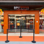 Alcino Soutinho’s Sede Norte do BPI showcasing a modern office building with a prominent glass façade, integrated advertising banners, and the BPI logo displayed on the exterior.