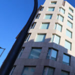 Alcino Soutinho’s design of Sede Norte do BPI showcasing a high-rise commercial building with a modern glass façade and sleek structural lines in an urban metropolitan area.