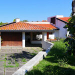Alcino Soutinho’s Soutinho Residence showcasing a modern residential house with a flat roof, large windows, and surrounding garden shrubs on a spacious land lot.