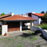 Alcino Soutinho’s Soutinho Residence showcasing a modern house with a sloped roof, expansive shaded terraces, and integration into a suburban residential area.