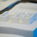 Scale model of Manuel Aires Mateus’s "7 Architectural Townhouses and 11 Architectural Villas, Lot 143" showcasing detailed plastic design elements and architectural plans.