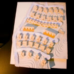 Atelier dos Remédios, Madalena Cardoso de Menezes and Francisco Teixeira Bastos’ architectural scale model of the 10 Architectural "Casa O" Villas, Lot 127, showcasing detailed paper plans and design diagrams.