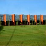 Gonçalo Byrne’s 25 Architectural Townhouses "Rusty Gates," Lot 217, showcasing modern townhouses with landscaped gardens, artificial turf lawns, and neatly trimmed hedges surrounding the eco-friendly residential campus.