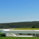 Nuno Brandao Costa’s 7 Architectural Villas, Lot 322, showcasing a modern villa with landscaped lawn, artificial turf, shaded outdoor areas, and farmhouse-inspired mansion elements.